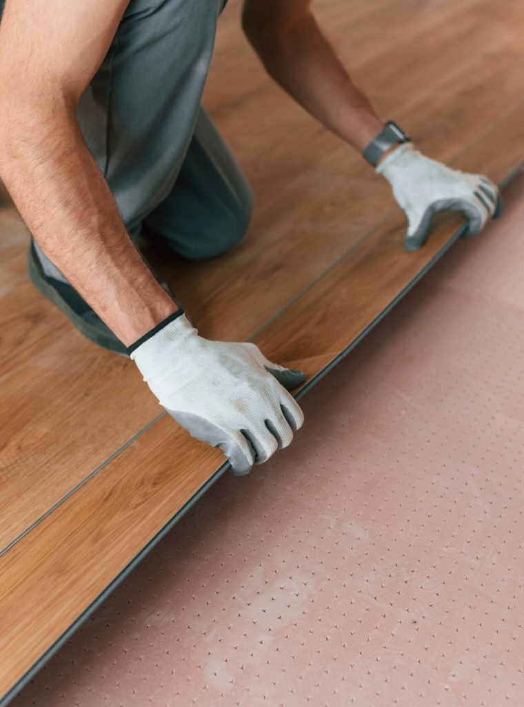 Man is installing new laminated wooden floor.